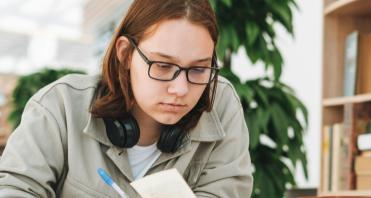 A student reading and taking notes in a library, from the Book Works case study
